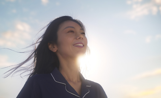 朝日を心地良さそうに浴びる女性