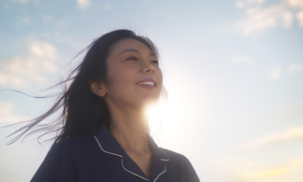 朝日を心地良さそうに浴びる女性