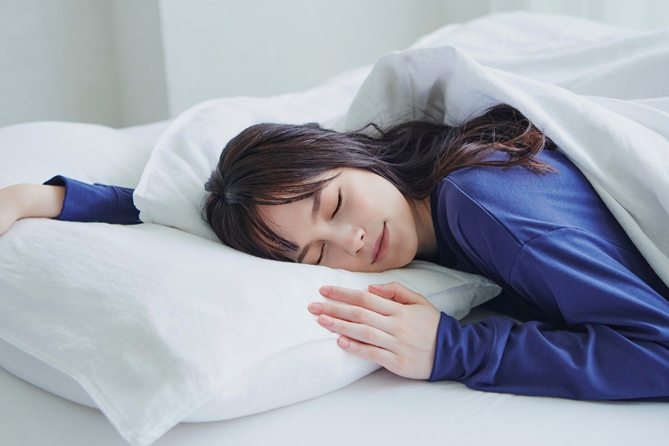 ベッドで心地よさそうに眠る女性