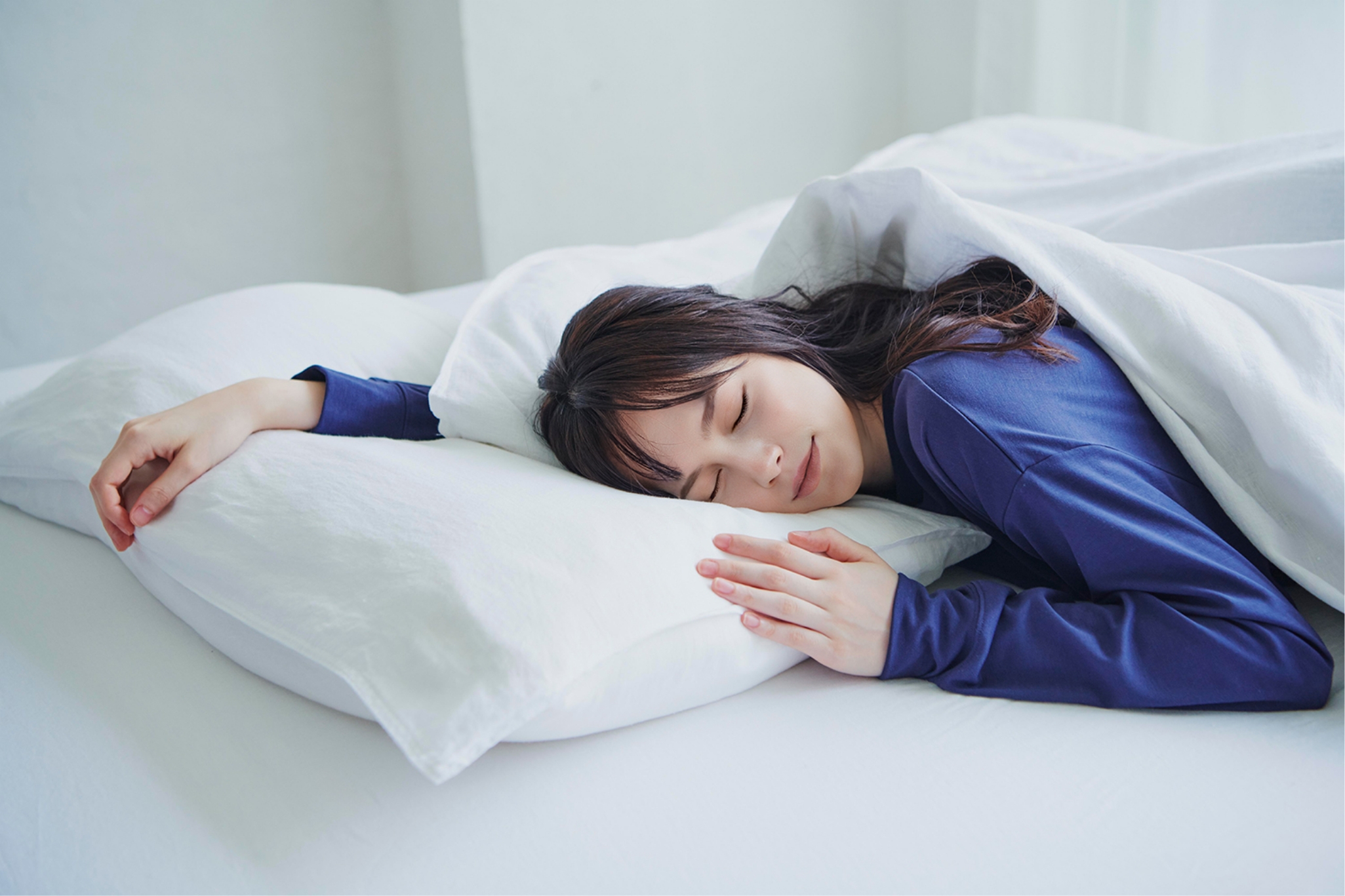 ベッドで心地よさそうに眠る女性