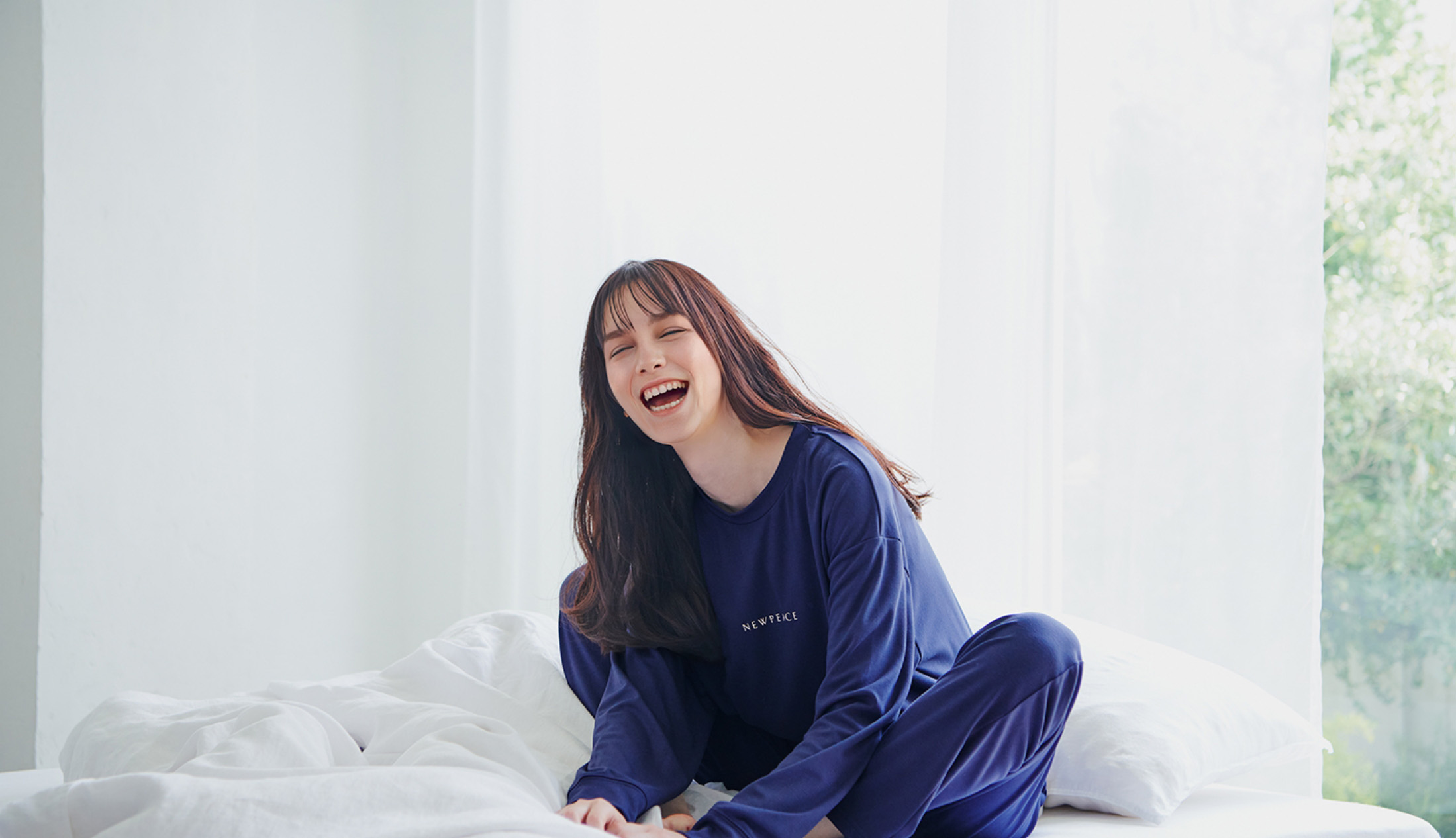 リカバリーウェアスリープを着て笑顔になる女性